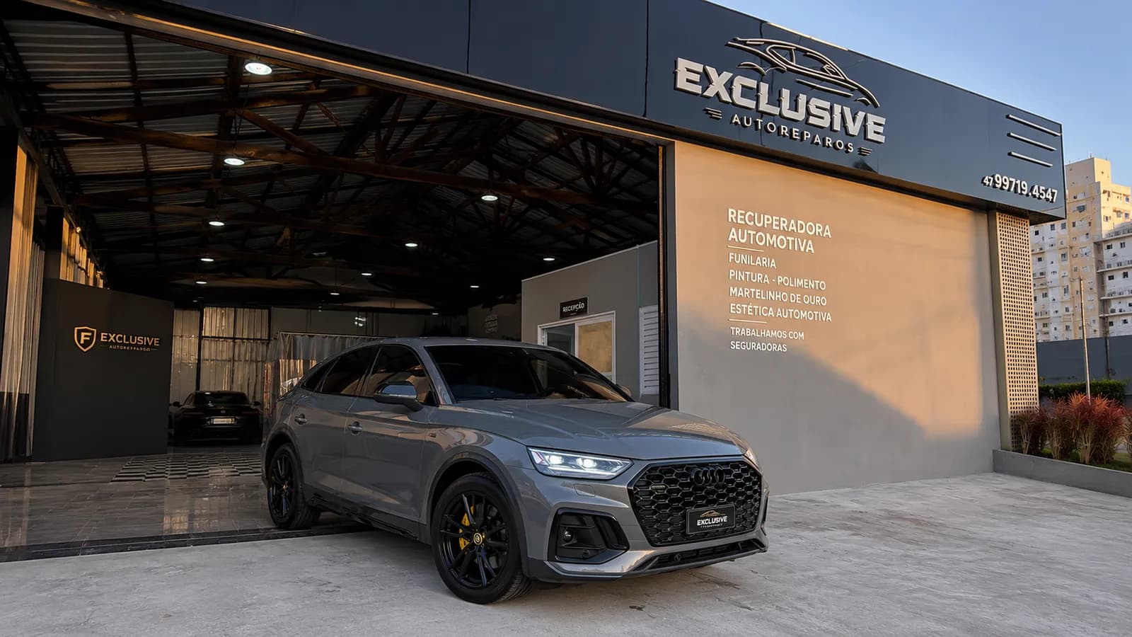 SUV Audi cinza esportivo na fachada da Exclusive Auto Reparos em Camboriú