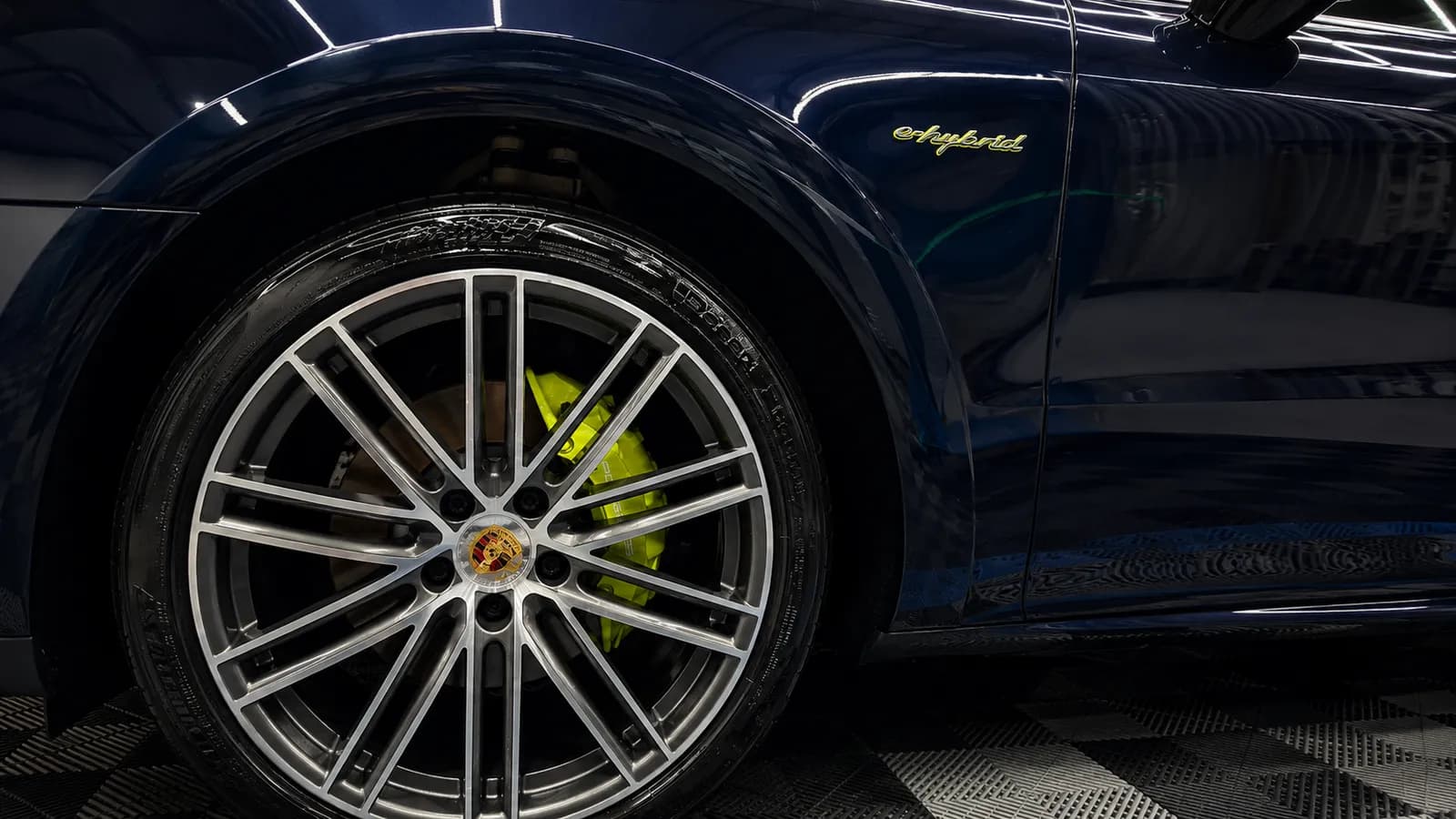 Roda esportiva de Porsche azul com pinça verde e acabamento detalhado